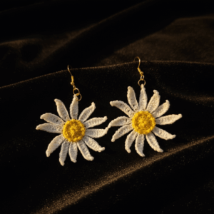 Boho handmade crochet daisy earrings styled on dark fabric background