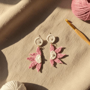 Handmade crochet earrings styled on beige linen background